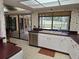 White kitchen cabinets, double sink, and view of the backyard at 2280 Toniwood Ln, Palm Harbor, FL 34685