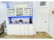 White bar cabinet with glass doors and blue LED lighting at 2602 W Nassau St, Tampa, FL 33607