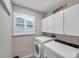 Laundry room with washer, dryer, and ample cabinet space at 2602 W Nassau St, Tampa, FL 33607