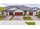 Three-unit building with attached garages and landscaping at 31428 Briars Ml, San Antonio, FL 33576