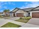 Modern home exteriors with attached garages and landscaping at 31428 Briars Ml, San Antonio, FL 33576