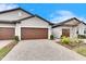 Two-car garage with paver driveway and well-manicured landscaping at 31428 Briars Ml, San Antonio, FL 33576