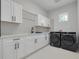Bright laundry room, with white cabinets and black appliances at 4306 W Barcelona St, Tampa, FL 33629