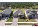 Aerial view of houses in a residential community with a pond nearby at 4661 Southern Valley Loop, Brooksville, FL 34601