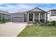 Gray two-story house with gray roof, paver driveway, and covered porch at 4661 Southern Valley Loop, Brooksville, FL 34601
