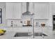 Close-up of kitchen sink and gas cooktop with white cabinets at 4661 Southern Valley Loop, Brooksville, FL 34601