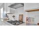 Gas cooktop detail with white cabinets and subway tile backsplash at 4661 Southern Valley Loop, Brooksville, FL 34601