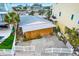 Aerial view of a pink cottage with board-up and a white fence, in a residential area at 501 180Th E Ave, Redington Shores, FL 33708