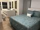 Well-lit bedroom featuring a queen bed with patterned comforter and daybed near windows at 501 180Th E Ave, Redington Shores, FL 33708