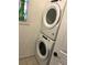 Modern laundry room showcasing a stacked white washer and dryer unit at 501 180Th E Ave, Redington Shores, FL 33708
