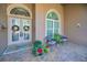 Elegant double front doors with sidelights, flanked by potted plants at 7330 Sawgrass Point N Dr, Pinellas Park, FL 33782