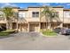 Tan townhouses with attached garages and lush landscaping at 809 Normandy Trace Rd, Tampa, FL 33602