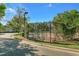 Tennis court surrounded by a fence and landscaping at 809 Normandy Trace Rd, Tampa, FL 33602
