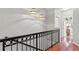Upper hallway with wood floors and an iron railing at 809 Normandy Trace Rd, Tampa, FL 33602