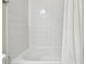 Bathroom with white tile, bathtub and shower curtain at 8126 Muddy Pines Pl, Tampa, FL 33635