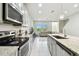 Modern kitchen with gray cabinets, granite counters, and island at 8126 Muddy Pines Pl, Tampa, FL 33635