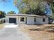 Newly renovated home with a white brick exterior and landscaping at 10322 N Oakleaf Ave, Tampa, FL 33612