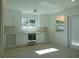 Modern kitchen with white cabinets, wine storage, and stainless steel appliances at 10322 N Oakleaf Ave, Tampa, FL 33612
