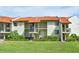 Condo building exterior with Spanish tile roofs and landscaping at 1515 Pinellas Bayway S # 70, Tierra Verde, FL 33715