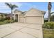 Tan house with two-car garage and lush landscaping at 315 19Th Nw St, Ruskin, FL 33570