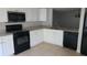 Modern kitchen with white cabinets, granite countertops, black appliances, and tile floors at 4745 Puritan Cir # 4745, Tampa, FL 33617