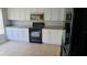 Modern kitchen with white cabinets, granite countertops, and black appliances at 4745 Puritan Cir # 4745, Tampa, FL 33617