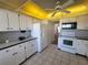 Kitchen with white cabinets, appliances, and a view to living room at 4895 Bay Ne St # 211, St Petersburg, FL 33703
