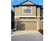 Two-story townhome with tan exterior, attached garage and concrete driveway at 5153 Bay Isle Cir, Clearwater, FL 33760