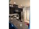 Modern kitchen features stainless steel appliances, granite countertops, and dark cabinetry at 5153 Bay Isle Cir, Clearwater, FL 33760