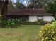 Ranch-style home with mature landscaping and a brown roof at 5824 58Th Street Ct, Tampa, FL 33619