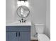 Modern bathroom with gray vanity and a round mirror at 6220 Westport Dr, Port Richey, FL 34668