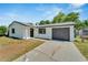 House exterior with dark garage door and front yard at 6220 Westport Dr, Port Richey, FL 34668