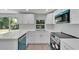 Modern kitchen with white cabinets and teal accents at 6220 Westport Dr, Port Richey, FL 34668