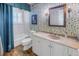 Charming bathroom with floral wallpaper, white vanity, and bathtub at 7172 Dr Martin Luther King Jr S St, St Petersburg, FL 33705
