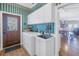 Bright laundry room with washer, dryer, and cabinets at 7172 Dr Martin Luther King Jr S St, St Petersburg, FL 33705