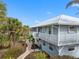Side view of a two-story home with a walkway leading to the water at 79 Palm Dr, Placida, FL 33946