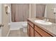 Clean bathroom with a tub, toilet, and vanity with granite top at 8506 Hunters Fork Loop, Ruskin, FL 33573