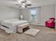 Bright bedroom featuring a king-size bed, plush rug, and ceiling fan at 8506 Hunters Fork Loop, Ruskin, FL 33573