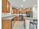 Modern kitchen with wood cabinets, granite countertops, and black appliances at 8506 Hunters Fork Loop, Ruskin, FL 33573
