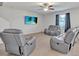 Spacious living room with grey reclining sofas and a large TV at 8506 Hunters Fork Loop, Ruskin, FL 33573