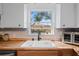 Modern kitchen sink with butcher block countertops and a view of the backyard at 8537 Cameo Dr, New Port Richey, FL 34654