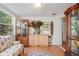 Bright sunroom with wood floors, built-in cabinets, and a comfy settee at 8537 Cameo Dr, New Port Richey, FL 34654