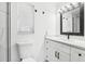 Modern bathroom with white vanity, black accents, and a framed mirror at 10904 90Th Ter, Seminole, FL 33772