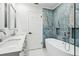 Elegant bathroom with double vanity, soaking tub, and marble tile at 10904 90Th Ter, Seminole, FL 33772