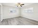 Bright bedroom with grey wood-look floors and ceiling fan at 10904 90Th Ter, Seminole, FL 33772