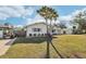 Side view of a white house with palm trees and a basketball hoop at 10904 90Th Ter, Seminole, FL 33772