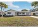 White house with gray roof, landscaping, and driveway at 10904 90Th Ter, Seminole, FL 33772