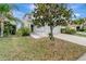 Neatly landscaped front yard with a large tree and driveway at 1107 Seminole Sky Dr, Ruskin, FL 33570