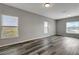 Large living room with gray walls, wood-look floors, and multiple windows at 1107 Seminole Sky Dr, Ruskin, FL 33570