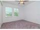 Bright bedroom with neutral carpeting and two windows at 11307 Linden Depot Rd, San Antonio, FL 33576